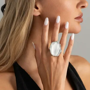 Primo piano di un anello d'argento con motivo a onde d'acqua sulla mano di una modella