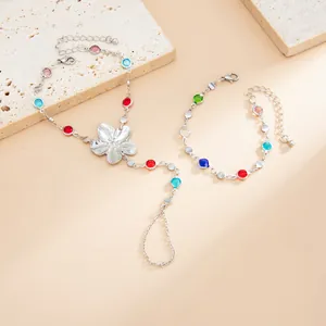 Detalle de la pulsera de anillo con flor de plata y conjunto con cristales multicolores