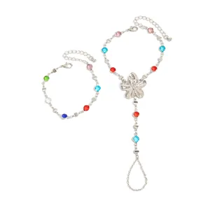Detalle del conjunto de pulsera y anillo de plata con cristales de colores y amuleto de flor