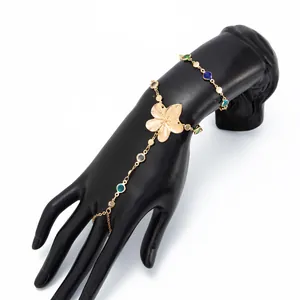 Vista detallada de una elegante pulsera de dedo con flor dorada y cristales de colores