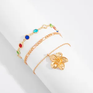 Detailed view of bohemian gold anklet set with colorful stones and flower pendant