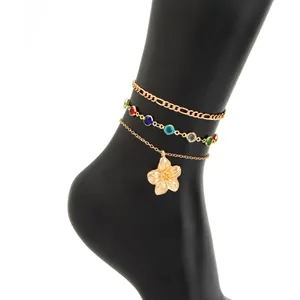 Exquisite gold-layered anklet set featuring vibrant colorful stones and a floral charm detail.