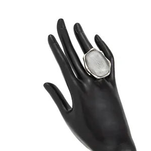 Dettaglio di un anello oversize in argento a onde d'acqua con pietra geometrica grigia