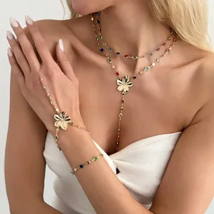 Vista detallada de un collar en Y dorado y una cadena de mano con cristales finos.
