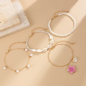 Set of bohemian beach anklets featuring shells, pearls, and a pink flower charm