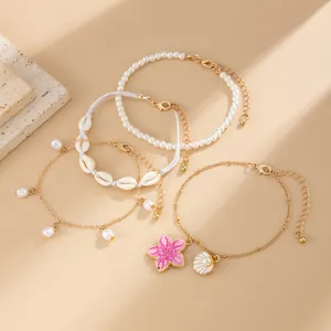 Set of four beach-themed anklets with pink flower shell charms and pearl beads details