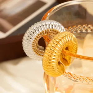 Detailed view of trendy ribbed C-shaped ear cuffs in gold and silver stainless steel