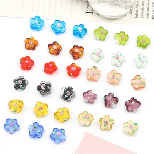 Primer plano de cuentas de vidrio con forma de flor de ciruelo para joyería DIY.