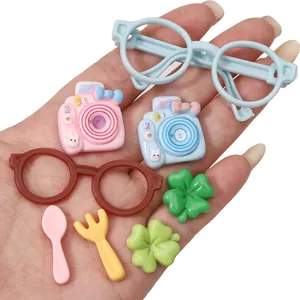 Selection of colorful resin DIY charms including cameras, glasses, and clovers