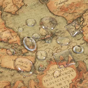 Close-up of assorted clear glass cabochons for DIY jewelry making on vintage map