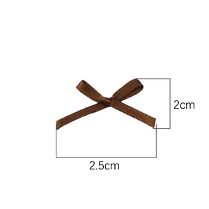 Dettaglio di un mini fiocco marrone con dimensioni 2,5 cm di larghezza e 2 cm di altezza.