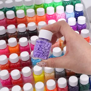 Hand holding a square clear bottle filled with purple fuse beads on a display rack