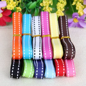 Assorted colorful grosgrain ribbons with white stitched edges for gift wrapping.