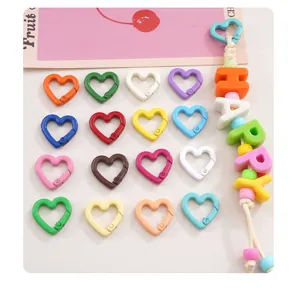 Close-up view of colorful heart-shaped carabiner clasps and HAPPY letter bead keychain DIY kit