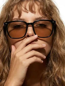 Primo piano di occhiali da sole quadrati alla moda con lenti marroni indossati da una modella