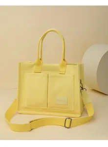 Vue détaillée d'un grand sac cabas en toile jaune avec poches et bandoulière