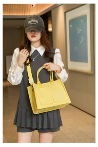 Sac fourre-tout en toile jaune avec poches avant et large bandoulière réglable
