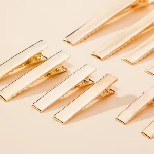 Detailed macro view of multiple golden metal duckbill hair clips for DIY handmade accessories