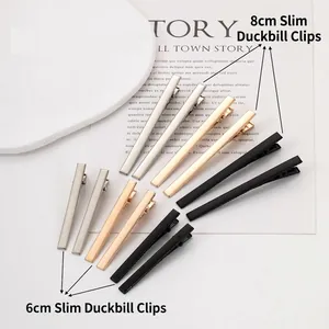 Detail of minimalist metal duckbill hair clips in 8cm and 6cm sizes, silver and gold