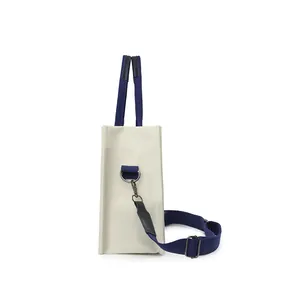 Vue latérale du sac fourre-tout en toile crème avec bandoulière bleue réglable en détail