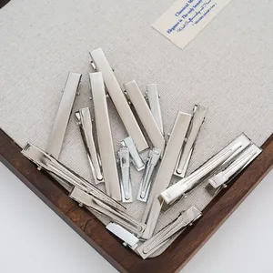 Macro detail of assorted silver metal duckbill hair clips for DIY accessory making