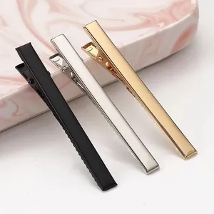 Trio of metal alligator hair clips in black silver and gold finishes close-up view