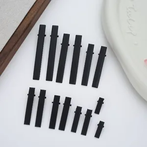 Multiple sizes of matte black metal duckbill hair clips for DIY hair accessories.