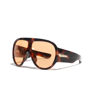 Oversized Y2K futuristic sunglasses with tinted orange lenses and tortoise frame