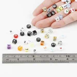 Gekleurde acryl alfabet kralen voor DIY sieraden maken getoond met een meetlat schaal.
