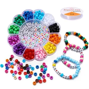 Close-up of DIY jewelry bead set including letter beads and colorful round beads in box.