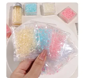 Close-up of colorful donut-shaped glass cat-eye beads in transparent bags for DIY jewelry.