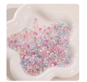 Close-up of pastel glass donut cat-eye beads for DIY jewelry making in a white bowl