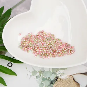Primer plano de perlas de imitación ABS rosas y verdes en plato de corazón