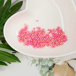 Primer plano de cuentas de perlas de imitación ABS redondas en un plato blanco de corazón