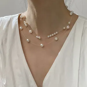 Elegant double-layered floating pearl necklace on transparent wire shown on neck.