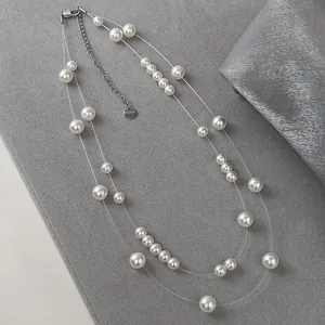 Detail of double-layer floating pearl necklace with invisible line design on gray fabric