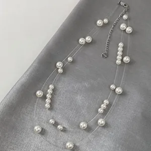 Macro detail of double-layered starry sky pearl necklace on textured grey silk background