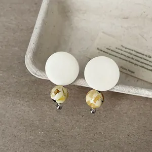 Close-up detail of retro wooden round earrings with amber textured natural stone beads