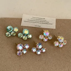 Detailed macro view of iridescent crystal flower stud earrings in three distinct colors