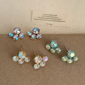 Detail view of iridescent crystal flower stud earrings in multiple pastel shades