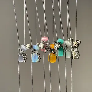 Close-up of elegant necklaces featuring Dalmatian jasper and colorful cat's eye pendants