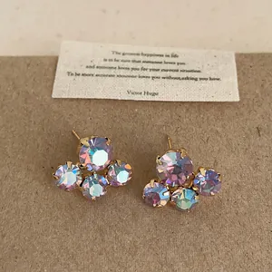 Close-up detailed view of iridescent crystal flower stud earrings with gold plating