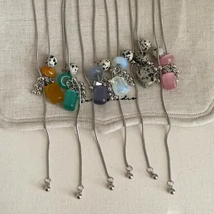 Detailed close-up view of colorful natural stone grape cluster necklaces on linen cloth
