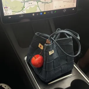 Primer plano de un colgante de manzana roja realista en un bolso vaquero tejido azul