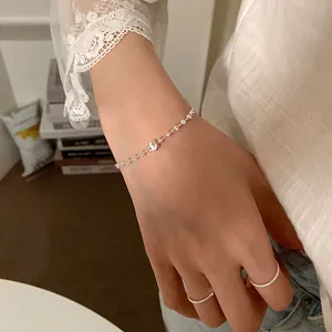 Détail d'un bracelet en argent minimaliste avec une perle brossée portée au poignet
