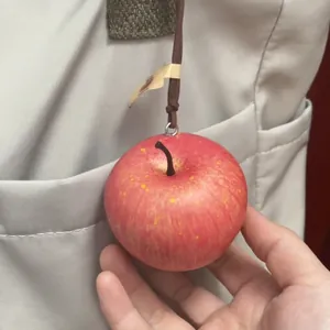 Primer plano de un colgante de manzana roja realista con textura y tallo detallados