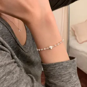 Gros plan détaillé d'un bracelet en argent minimaliste avec une sphère brossée