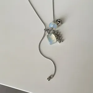 Close-up of long adjustable snake chain necklace with Dalmatian stone and opalite charms