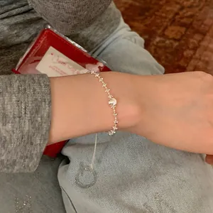 Détail du bracelet argenté minimaliste avec boule brossée porté au poignet.
