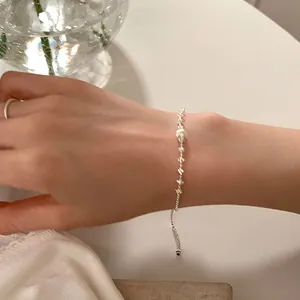 Gros plan d'un bracelet en argent ajustable avec une boule brossée sur le poignet